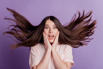 Surprised happy beautiful woman wind blow hairstyle open mouth on purple background