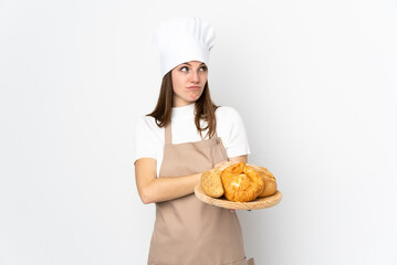 Young woman in chef uniform isolated on white background thinking an idea