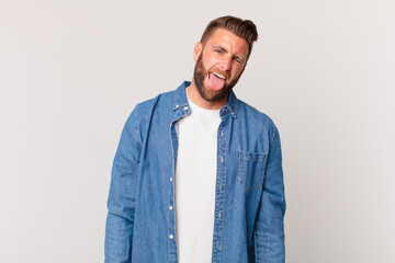 young handsome man with cheerful and rebellious attitude, joking and sticking tongue out