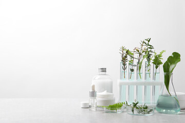 Organic cosmetic product, natural ingredients and laboratory glassware on white table, space for...
