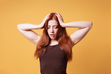 Fototapeta premium stressed exhausted young woman holding head suffering from headache or nervous breakdown