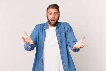 young handsome man feeling extremely shocked and surprised