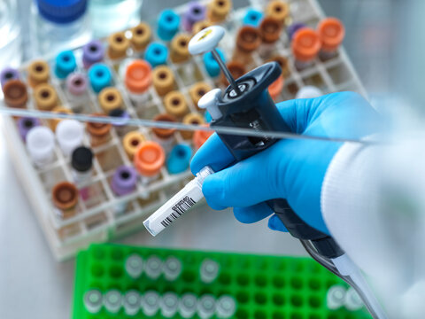 UK, Buckinghamshire, High Wycombe, Scientist holding vial and pipette