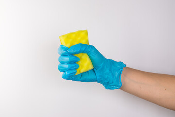 Sponge for washing dishes in female hand. Hand in a latex glove. Woman's hand gesture or sign isolated on white. A hand in a glove holds a sponge for washing and cleaning dishes