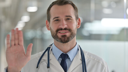 Portrait of Friendly Male Doctor Talking on Video Call 