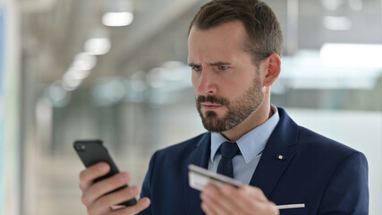 Portrait of Middle Aged Businessman having Online Payment Failure on Smartphone 