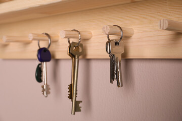 Wooden hanger for keys on color wall, closeup