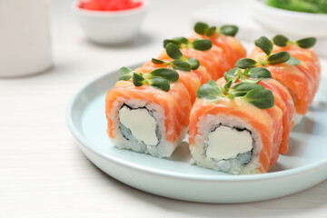 Tasty sushi rolls with salmon served on white table, closeup