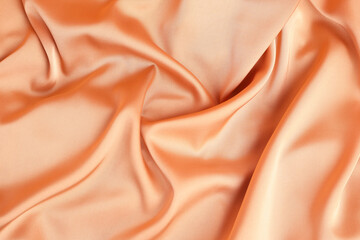 Texture of peach silk as background, above view
