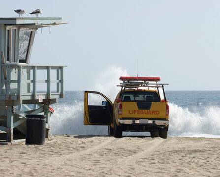 Large wave crashing into a lifeguard vehicle on the beach