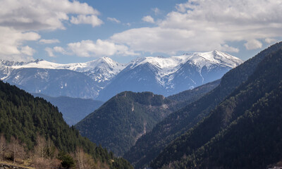 photo of the snowy Pyrenees of Andorra through forest and trails under blue sky