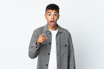Young brazilian man isolated on white background surprised and pointing front