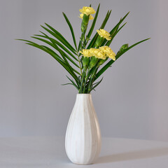 gelbe Nelken in weißer Vase