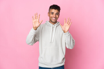 Young Brazilian man isolated on pink background counting ten with fingers