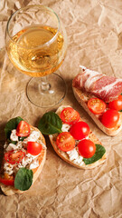 Bruschetta with cherry tomatoes. Wine glass, Italian appetizer.