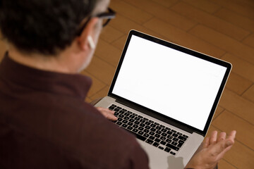 Fototapeta na wymiar Dettaglio di un uomo che lavora al computer e si connette in contesto domestico