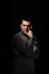 A man looks threateningly and thoughtfully at the camera