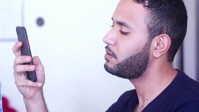 Man using his smartphone looking at camera and smiling