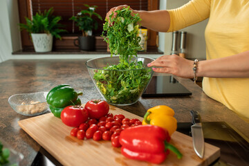 Fresh herbs hands of woman housewife. mom wife preparing salad of fresh vegetables and greens cherry tomatoes rucola pepper. domestic life. healthy food concept