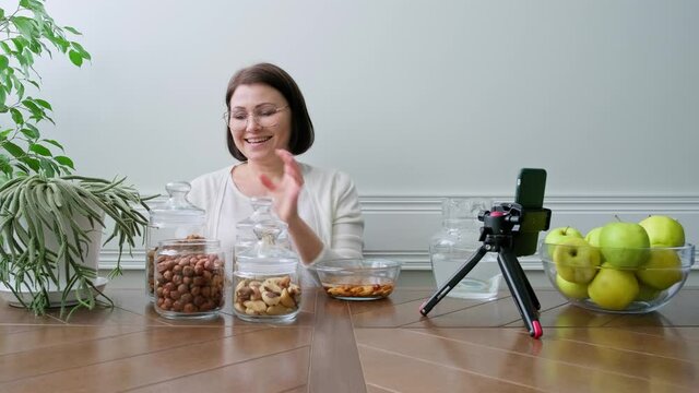 Activation vitamins in nuts. Woman nutritionist soaking nuts in water, consulting online