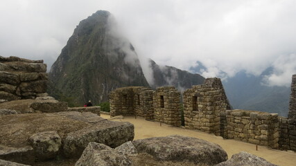 ruins of the fortress machu picchu with white fog and brown landscape