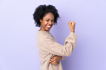 Young African American woman isolated on purple background celebrating a victory