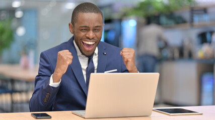 Excited African Businessman Celebrating Success on Laptop in Office 