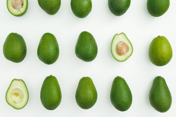Avocado whole and half pattern on white. Flat lay, top view. Food concept.