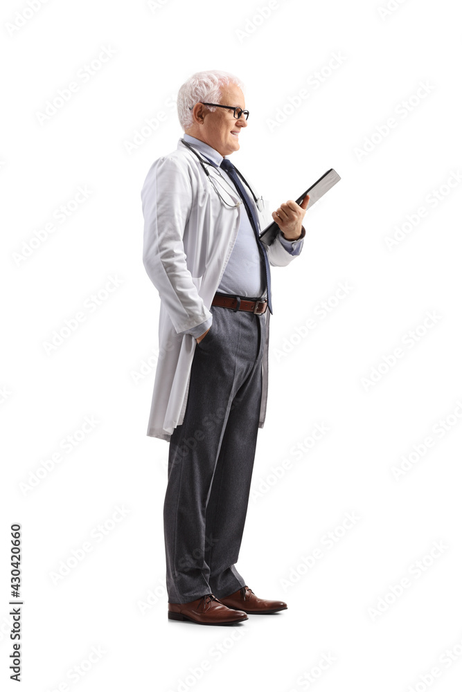 Wall mural full length profile shot of a mature male doctor standing and holding a clipboard