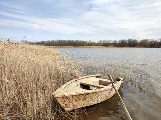 Old wooden fishing boat on river or pond