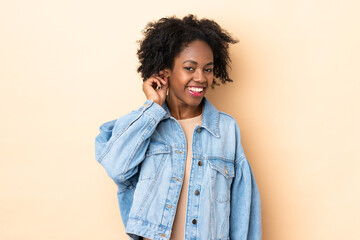 Young African American woman isolated on beige background laughing