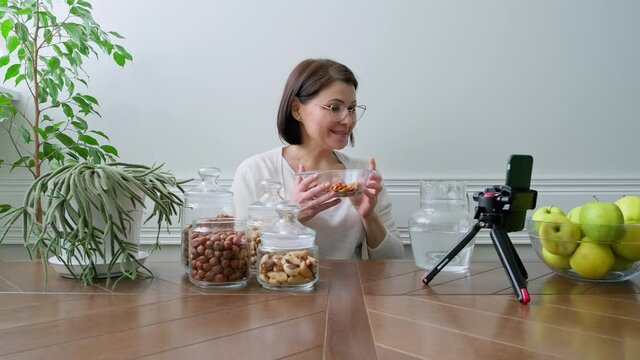 Activation vitamins in nuts. Woman nutritionist soaking nuts in water, consulting online