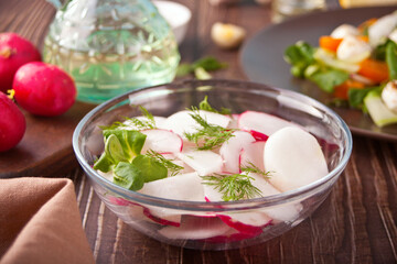 Spring fresh salad with radish and basil on the dinner table