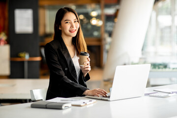 Fototapeta premium Portrait of Accounting businesswoman working on note laptop computer and analyzing real estate investment data, Financial and tax systems concept.