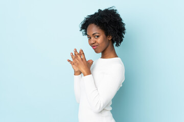 Young African American woman isolated on blue background scheming something