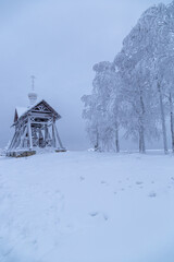 an iron bell covered with frost and snow on a frosty day on the top of Mount Belorie next to the Belogorsk monastery. Ural, Russia.