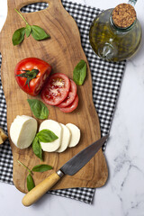 Homemade Italian caprese salad with sliced tomatoes, mozzarella cheese, basil and olive oil