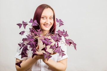 Woman with purple Oxalis triangularis house plant