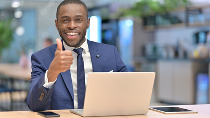 African Businessman with Laptop doing Thumbs Up in Office 