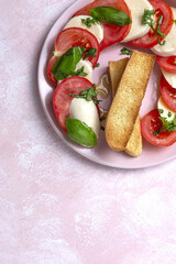 Homemade Italian caprese salad with sliced tomatoes, mozzarella cheese, basil and olive oil