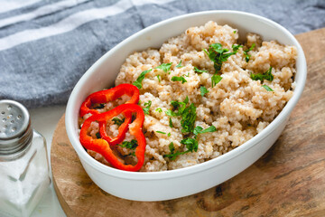 Cooked barley grains in a white bowl. Healthy food