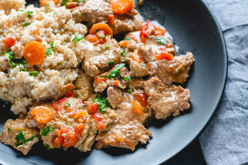 Beef stew in gravy with vegetables, served with barley groats