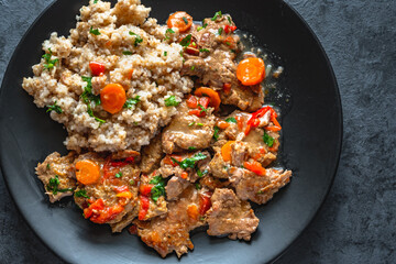Beef stew in gravy with vegetables, served with barley grains