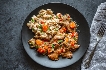 Beef stew in gravy with vegetables, served with barley
