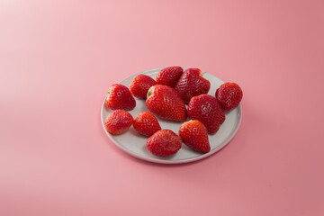 Delicious juicy ripe red strawberries on a pink background. Close-up shot of strawberries on a grater. Macro shot of garden strawberry