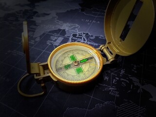 Golden compass on black map