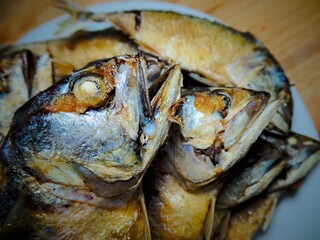 Fried mackerel is placed on top of each other on a plate.