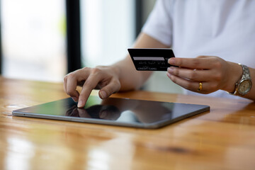 Close up woman hand using credit card and smartphone laptop for buying online shopping