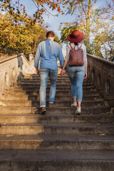 A beautiful young tourist couple are walking up stairs and looking around the castle of Buda in Budapest in autumn