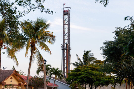 Coral Springs, Florida, USA - April 27, 2021: North Springs Improvement operating noisy, ground shaking, pool home damaging, ugly deep injection waste water well construction tower in Westview Estates